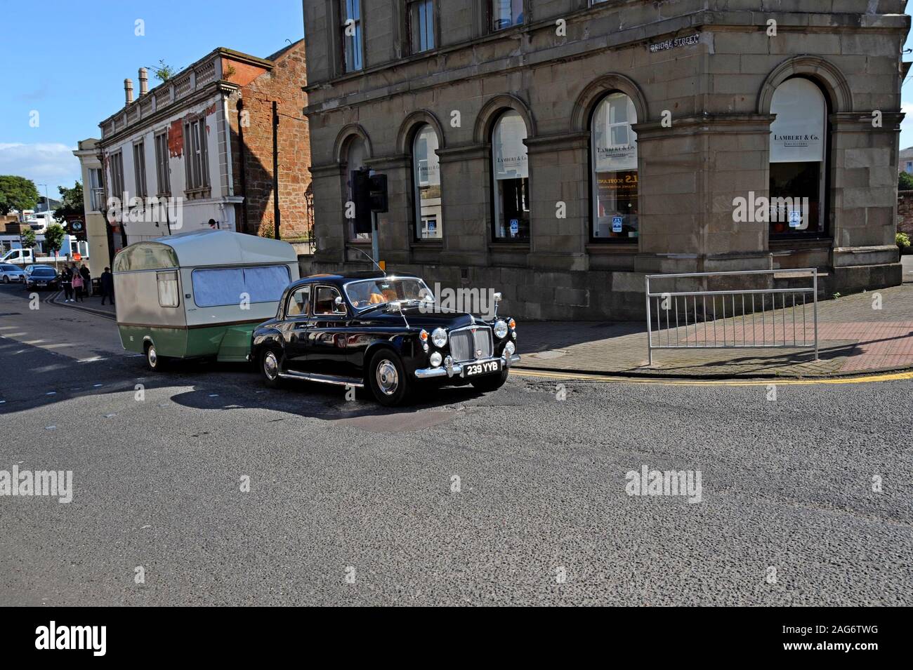A 1964 Rover 110 saloon classic car towing a vintage caravan through the centre of Girvan, Ayrshire, Scotland Stock Photo