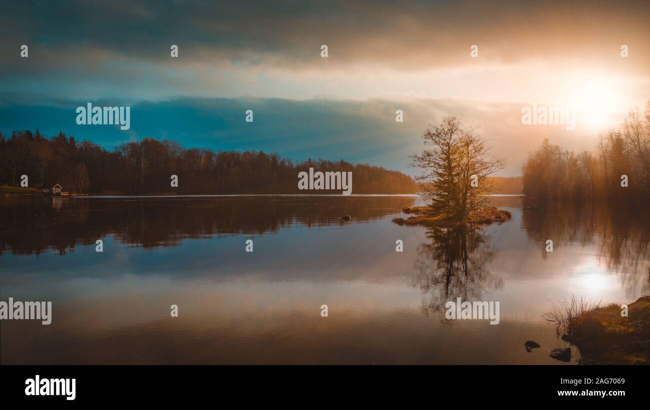 Reflection of the trees in a lake under the amazing colorful sky ...