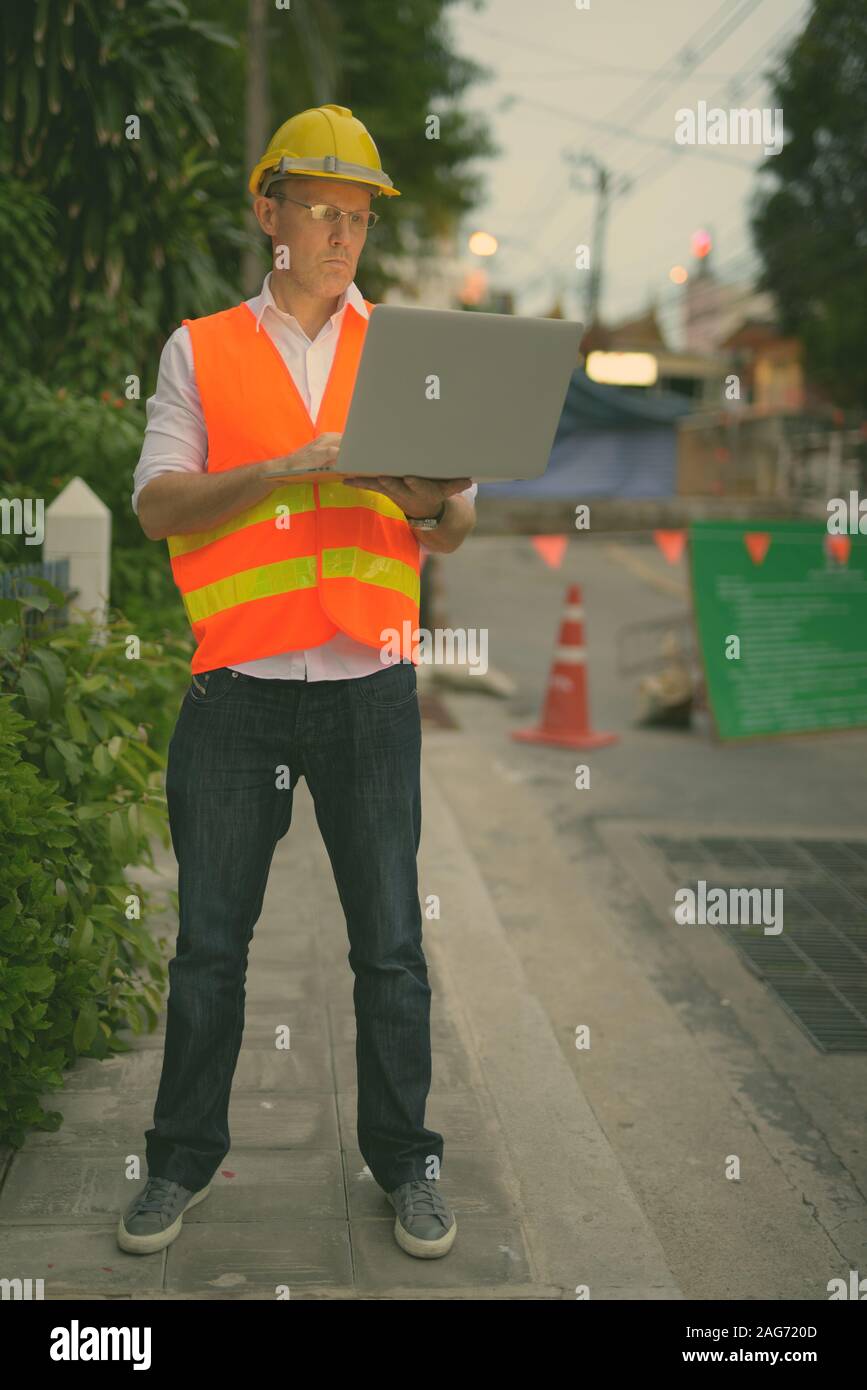 Mature man construction worker at the construction site in the city Stock Photo