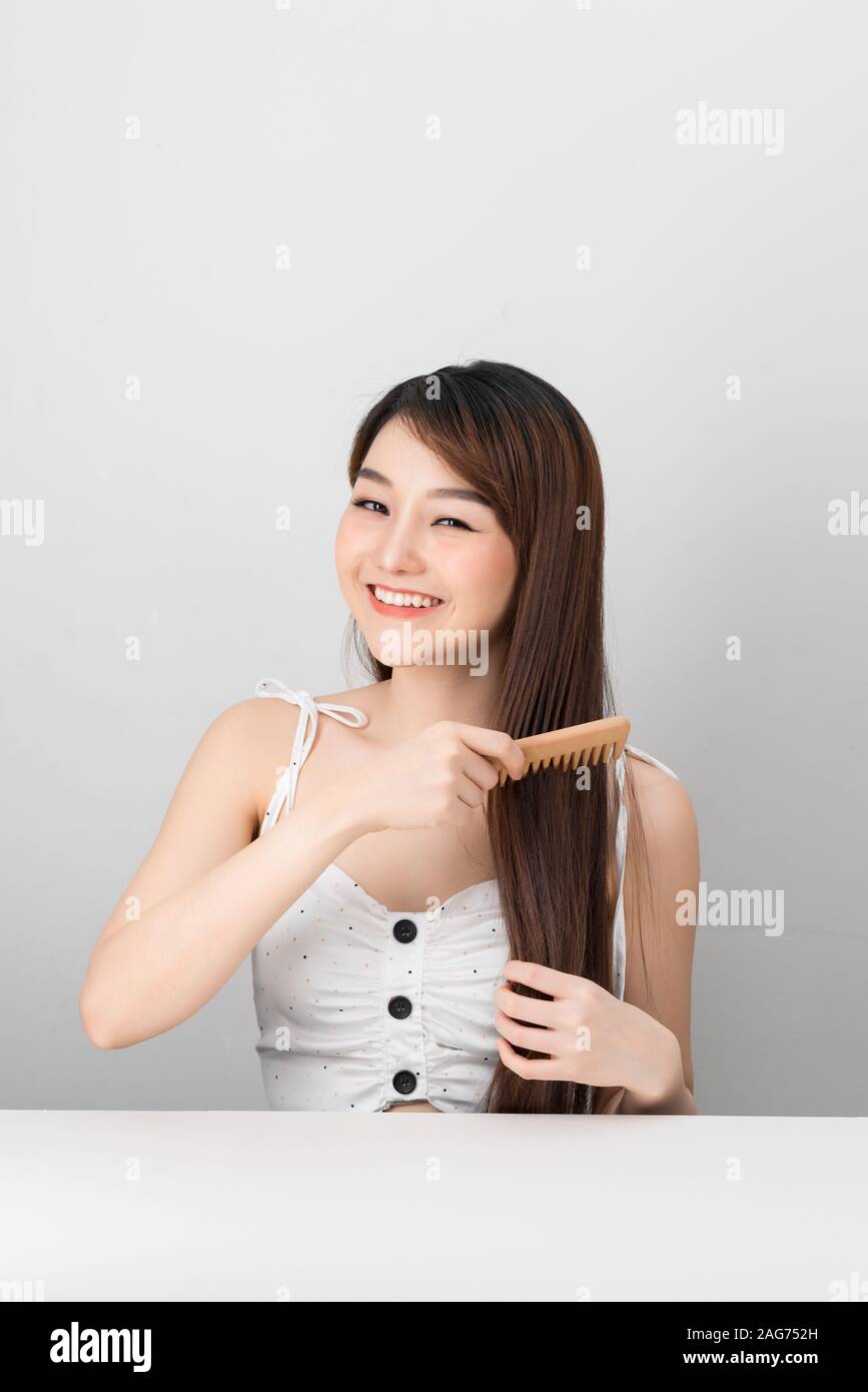 Beautiful girl combs her hair Asian appearance Stock Photo