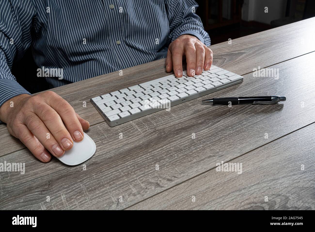 a man at work in front of a computer keyboard Stock Photo