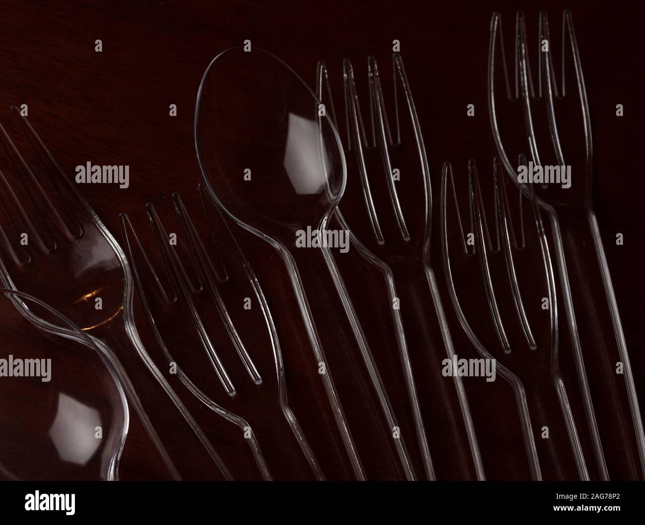 Transparent plastic spoon and fork on wooden table Stock Photo