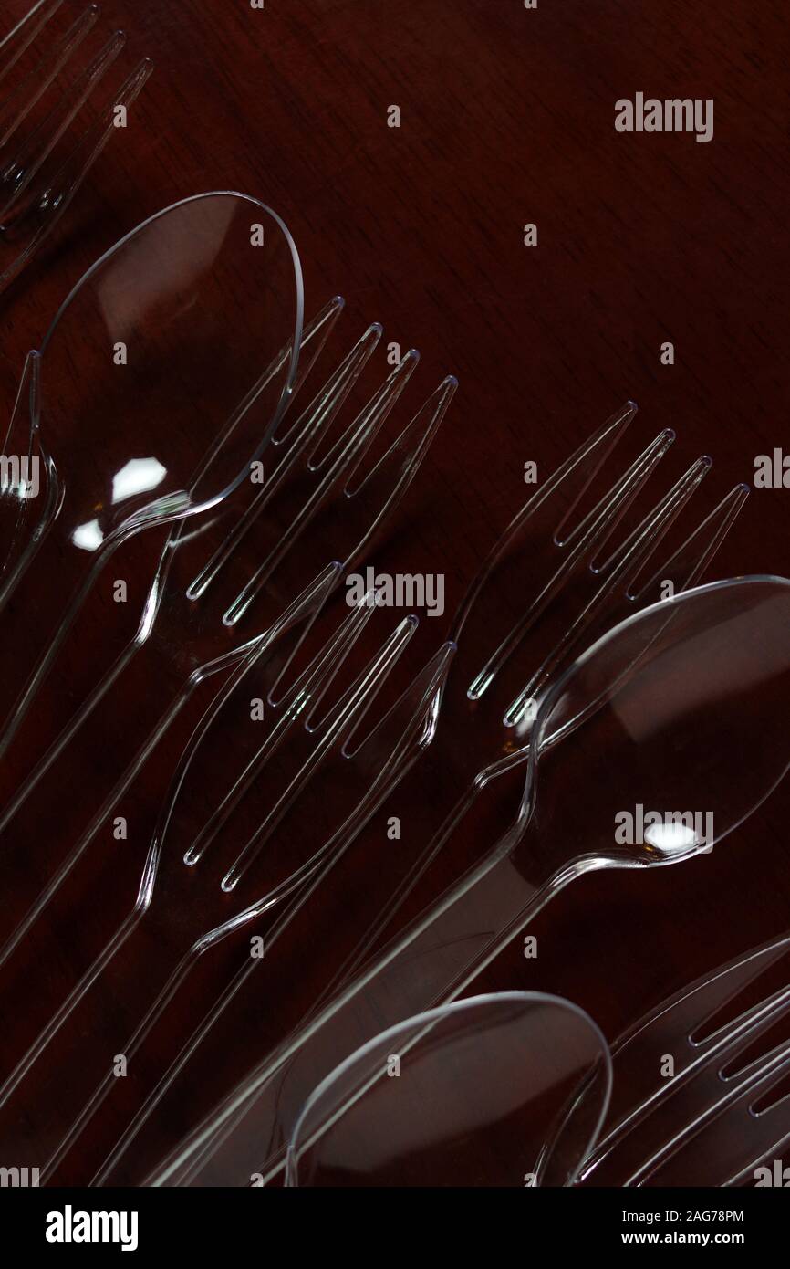 Transparent plastic spoon and fork on wooden table Stock Photo