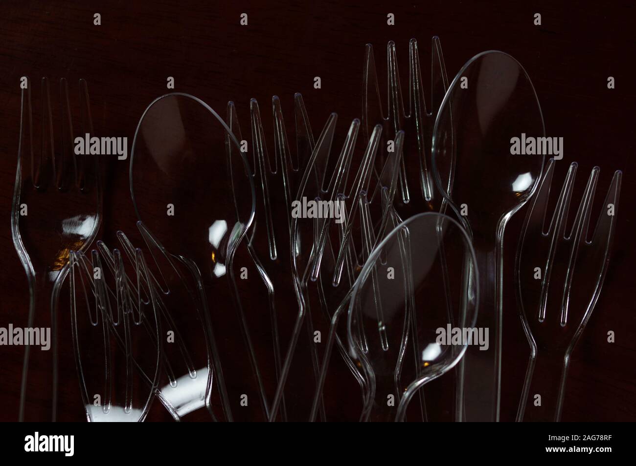 Transparent plastic spoon and fork on wooden table Stock Photo