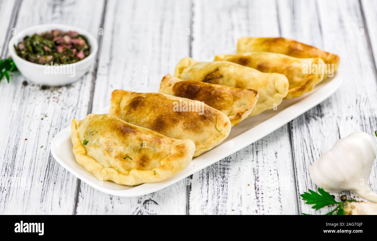 Wooden table with fresh homemade Empanadas (detailed closeup shot