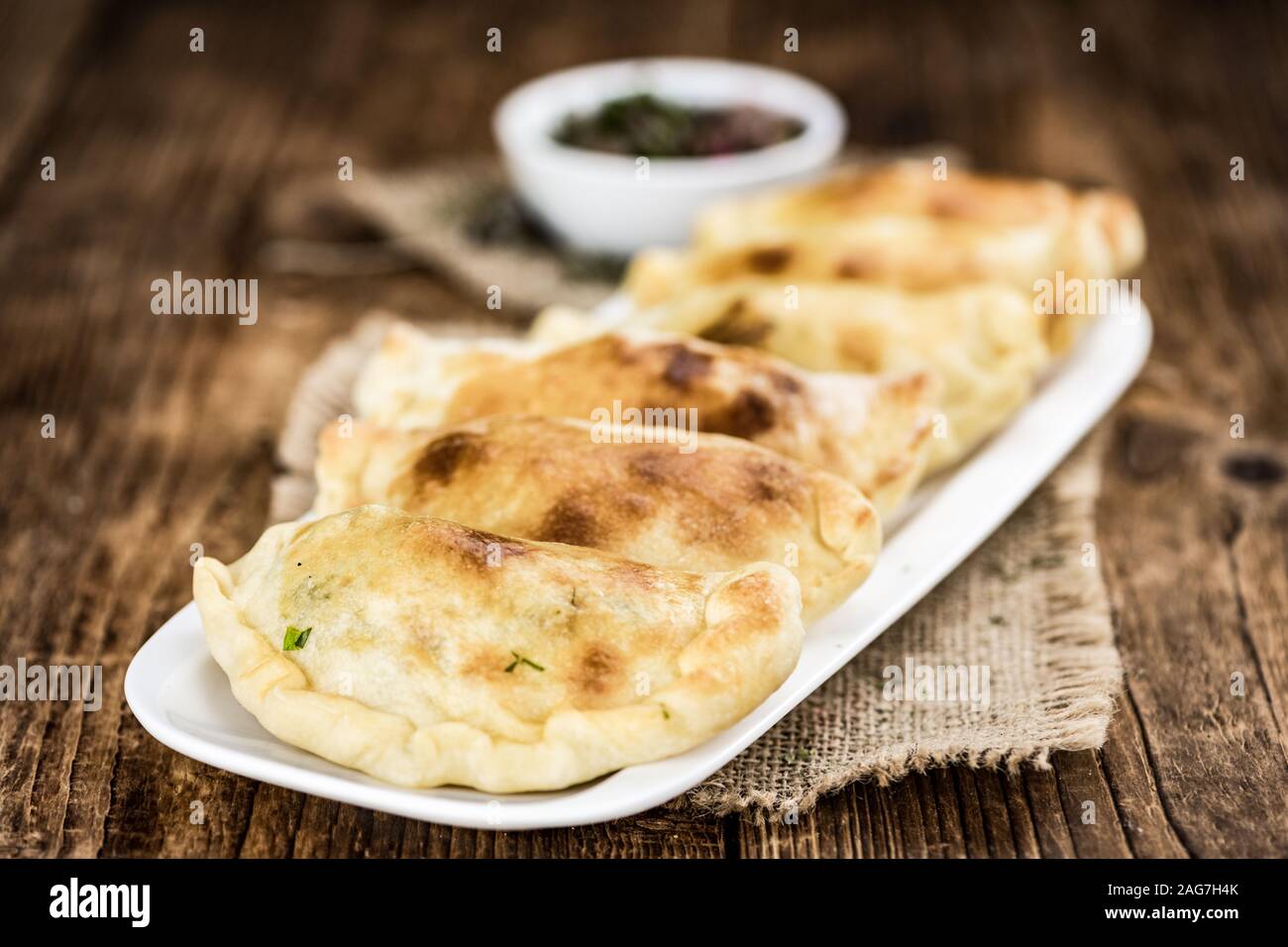 Wooden table with fresh homemade Empanadas (detailed close-up shot; selective focus) Stock Photo
