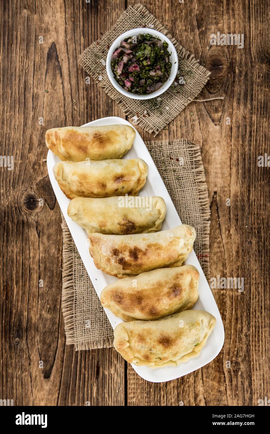 Portion of healthy Empanadas on an old wooden table (selective focus; close-up shot) Stock Photo