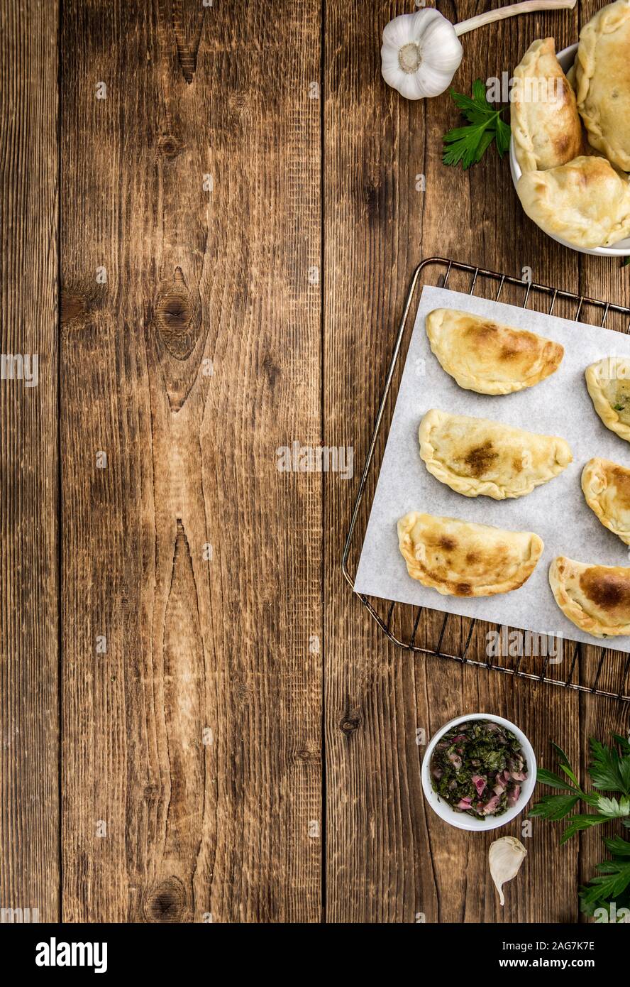 Wooden table with fresh homemade Empanadas (detailed closeup shot