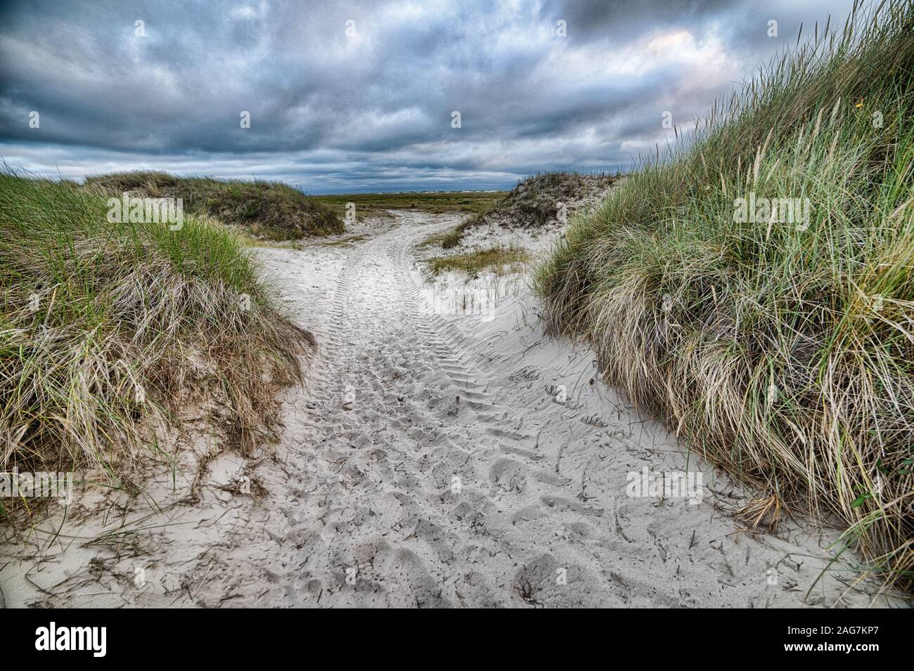 Sandy pathway surrounded by hill under the cloudy sky Stock Photo - Alamy