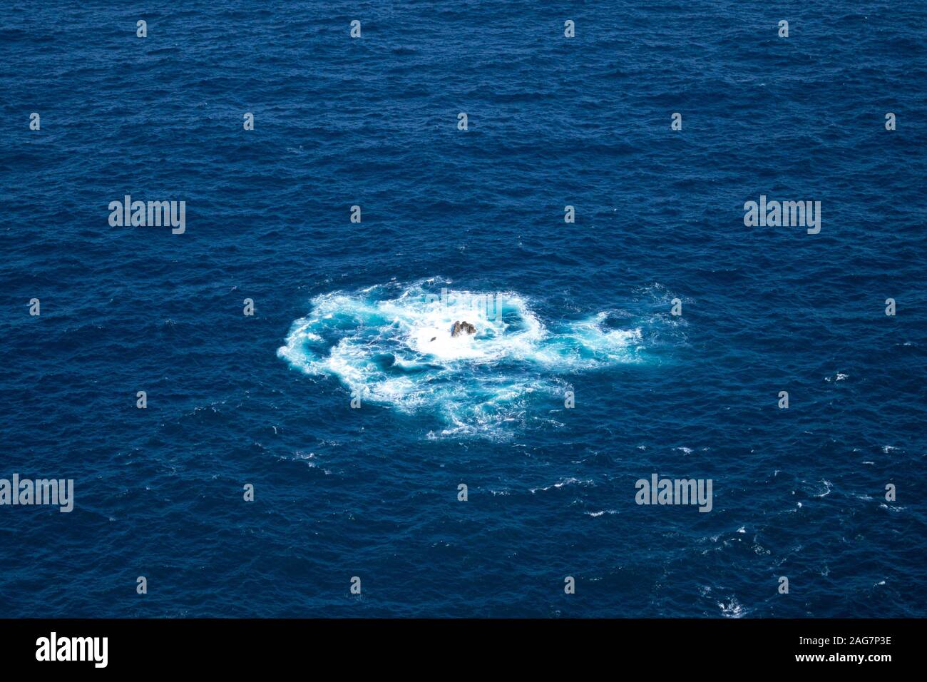 High angle shot of a splash in blue ocean water created by throwing an ...
