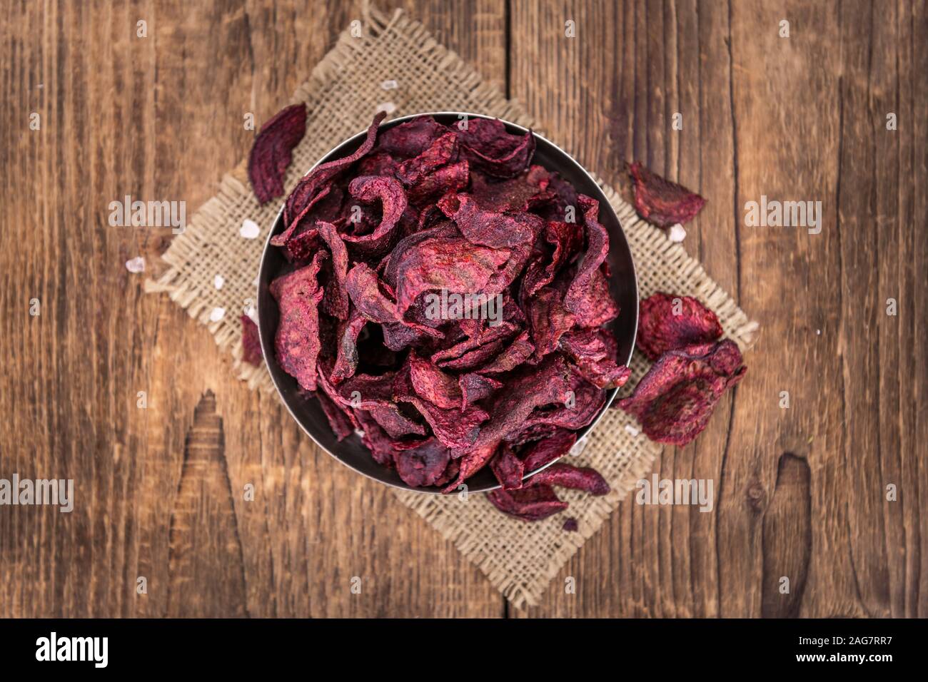 Wooden table with Beetroot Chips (detailed close-up shot; selective focus) Stock Photo