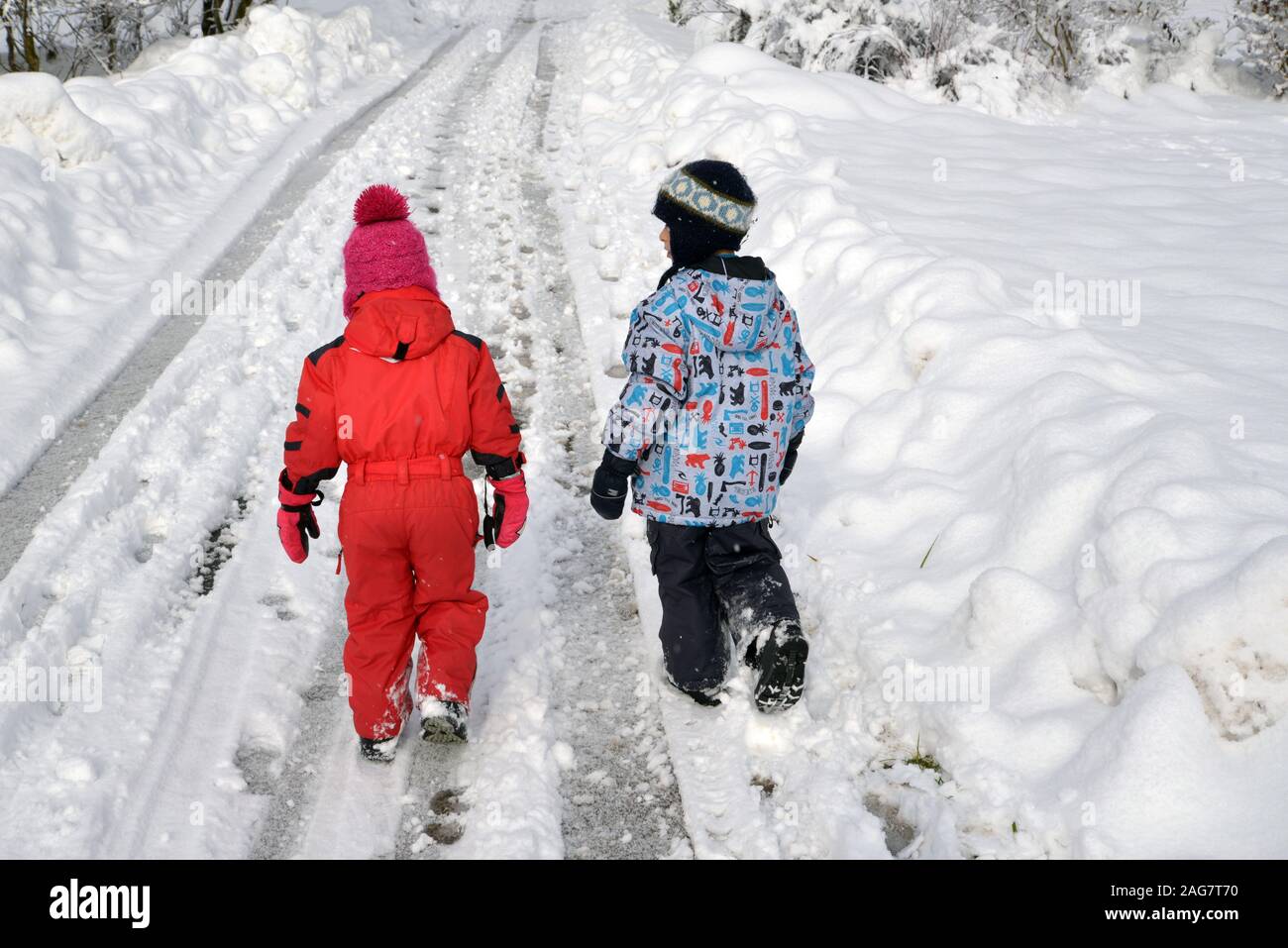 Brother and sister walking on a snowed mountain road Savoie Stock Photo ...