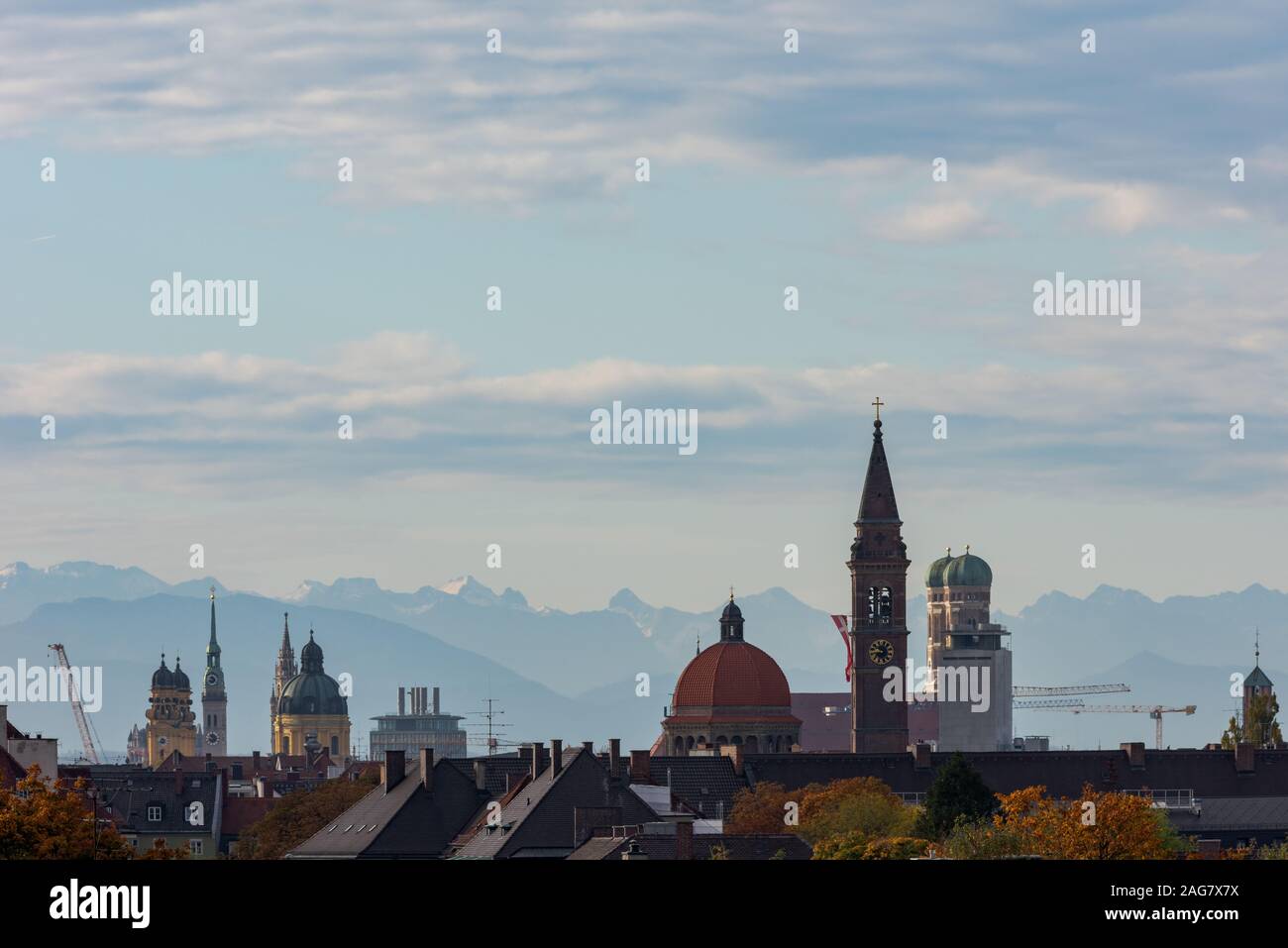 Rooftop view of churches in Munich with alpine mountains in the background Stock Photo