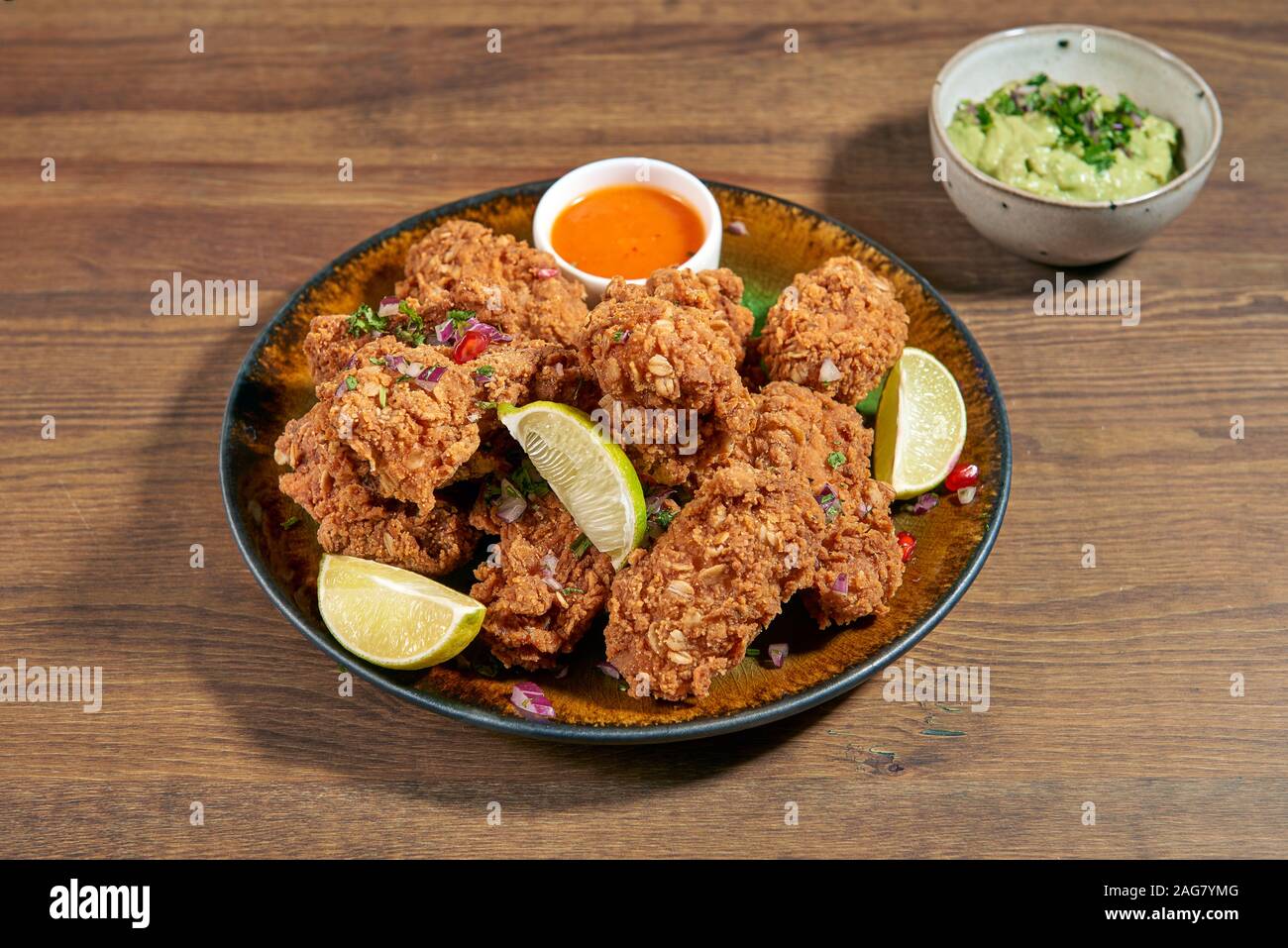 Fried crispy chicken with spicy coating and chili salsa with agave
