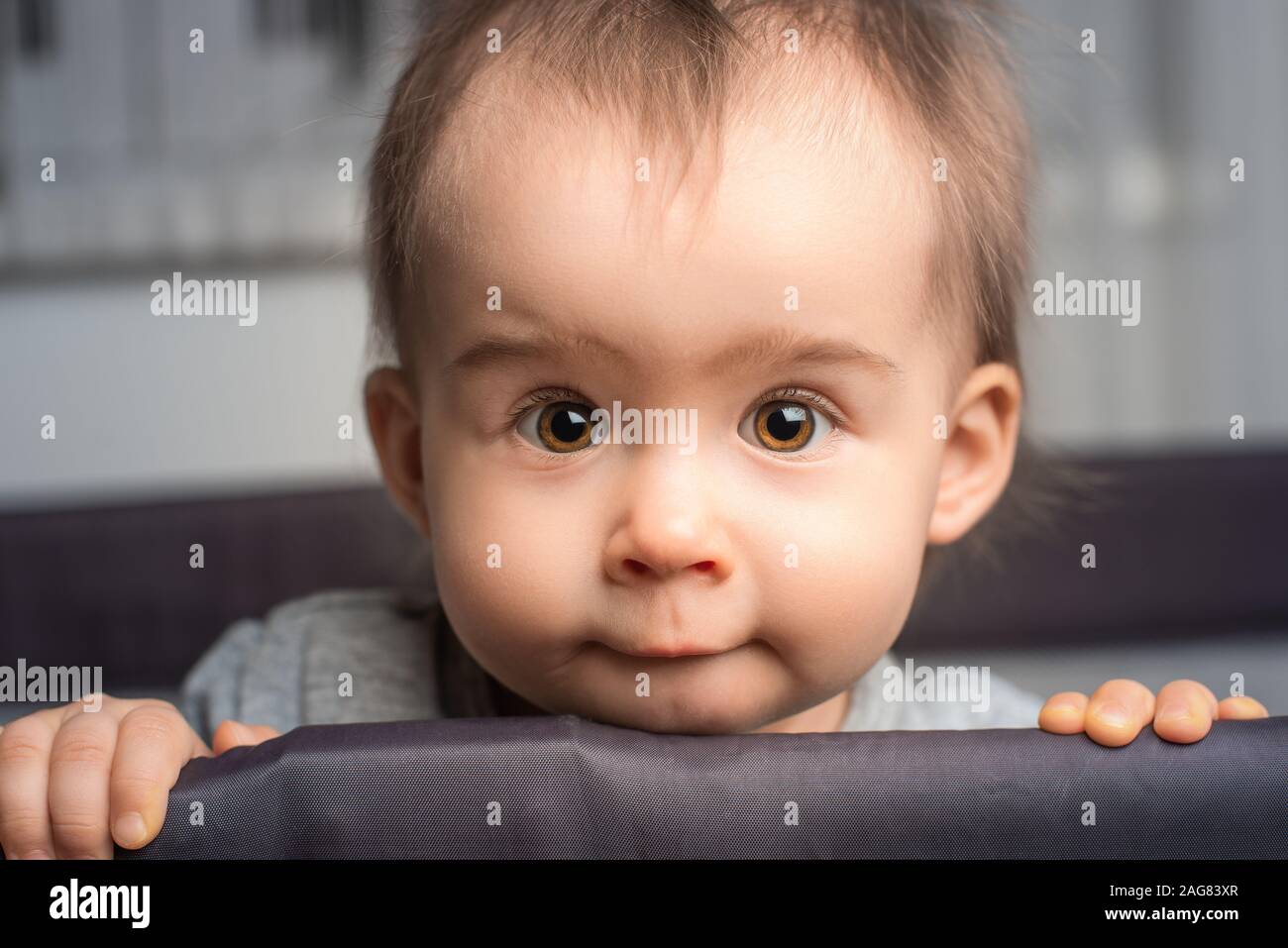 Portrait of cute one year old baby girl with big brown eyes. Stock Photo