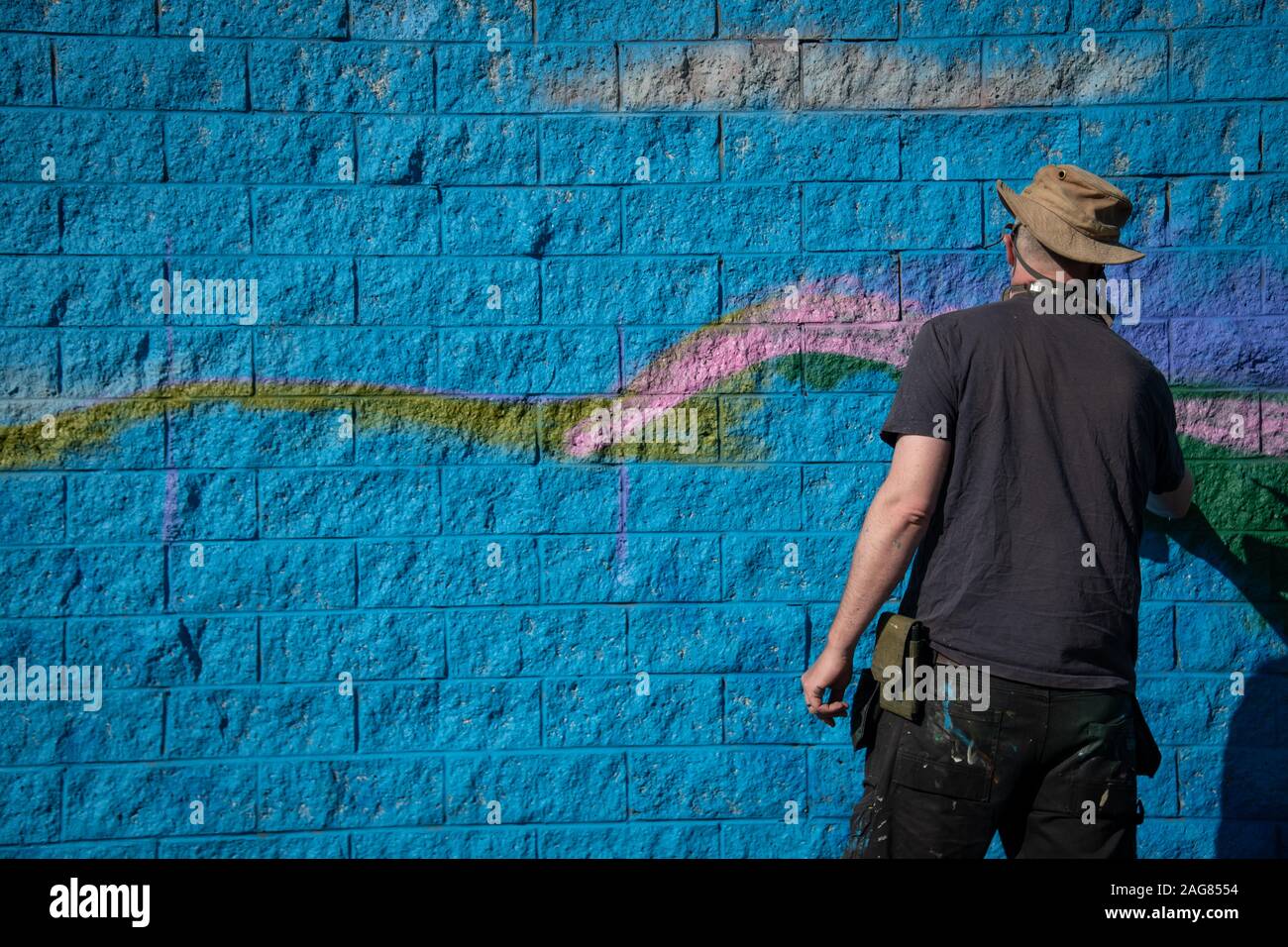 Ebbw Vale, UK - September 13, 2019: Graffiti artist painting building wall art with spray paints for the owl sanctuary for the town in Ebbw Vale, Wale Stock Photo