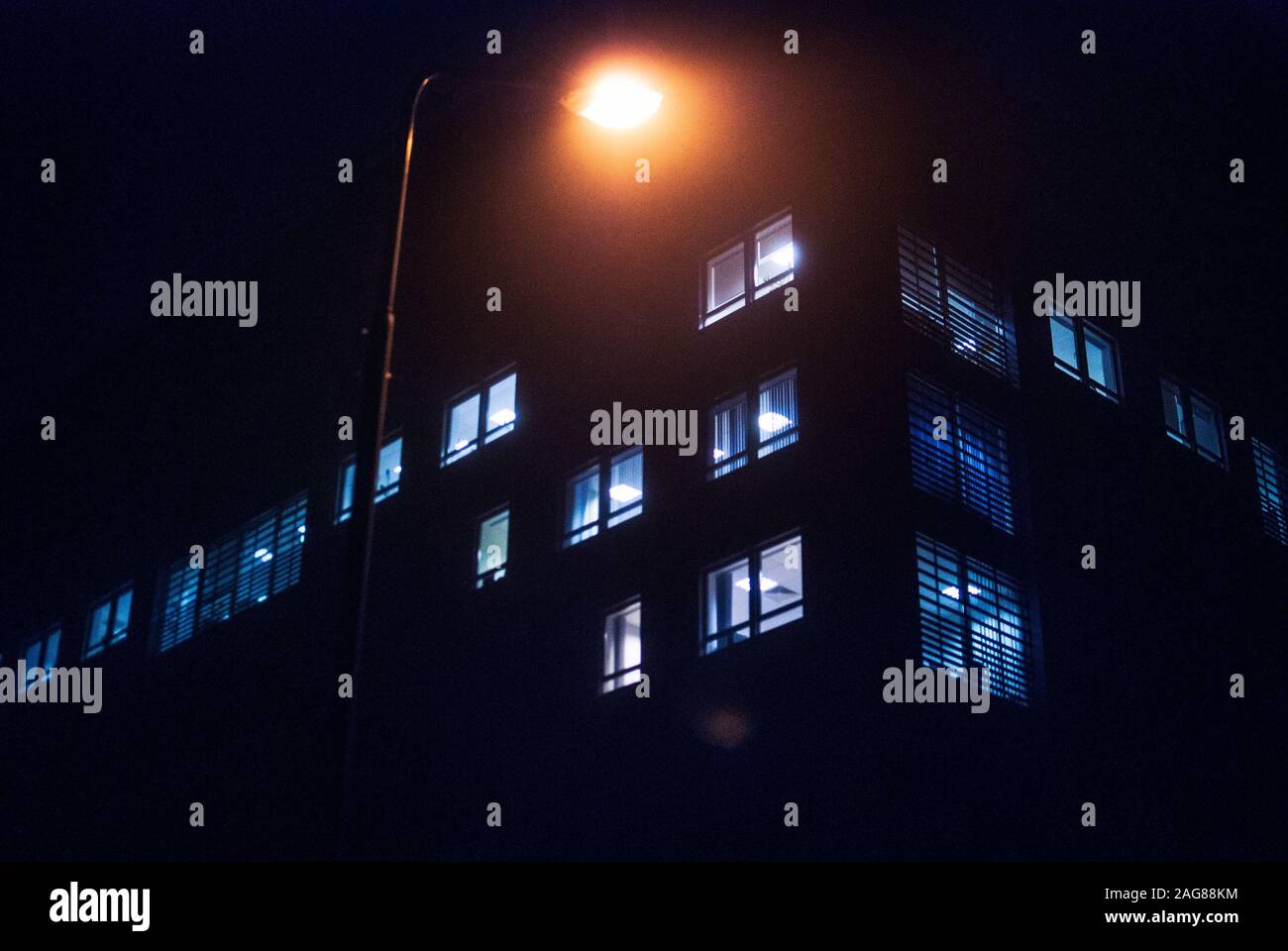 Low angle shot of the lights of a building under a street light taken at night in Poznan, Poland Stock Photo