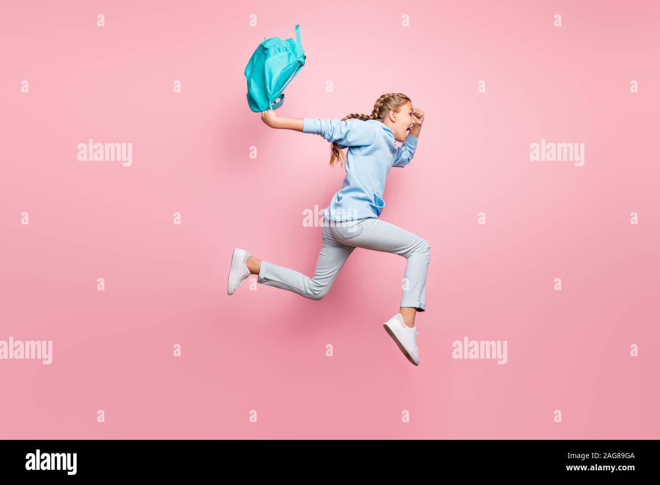 Full body profile photo of pretty little lady jumping high rushing home after studying week wear pupil backpack casual sweater clothes isolated pink Stock Photo