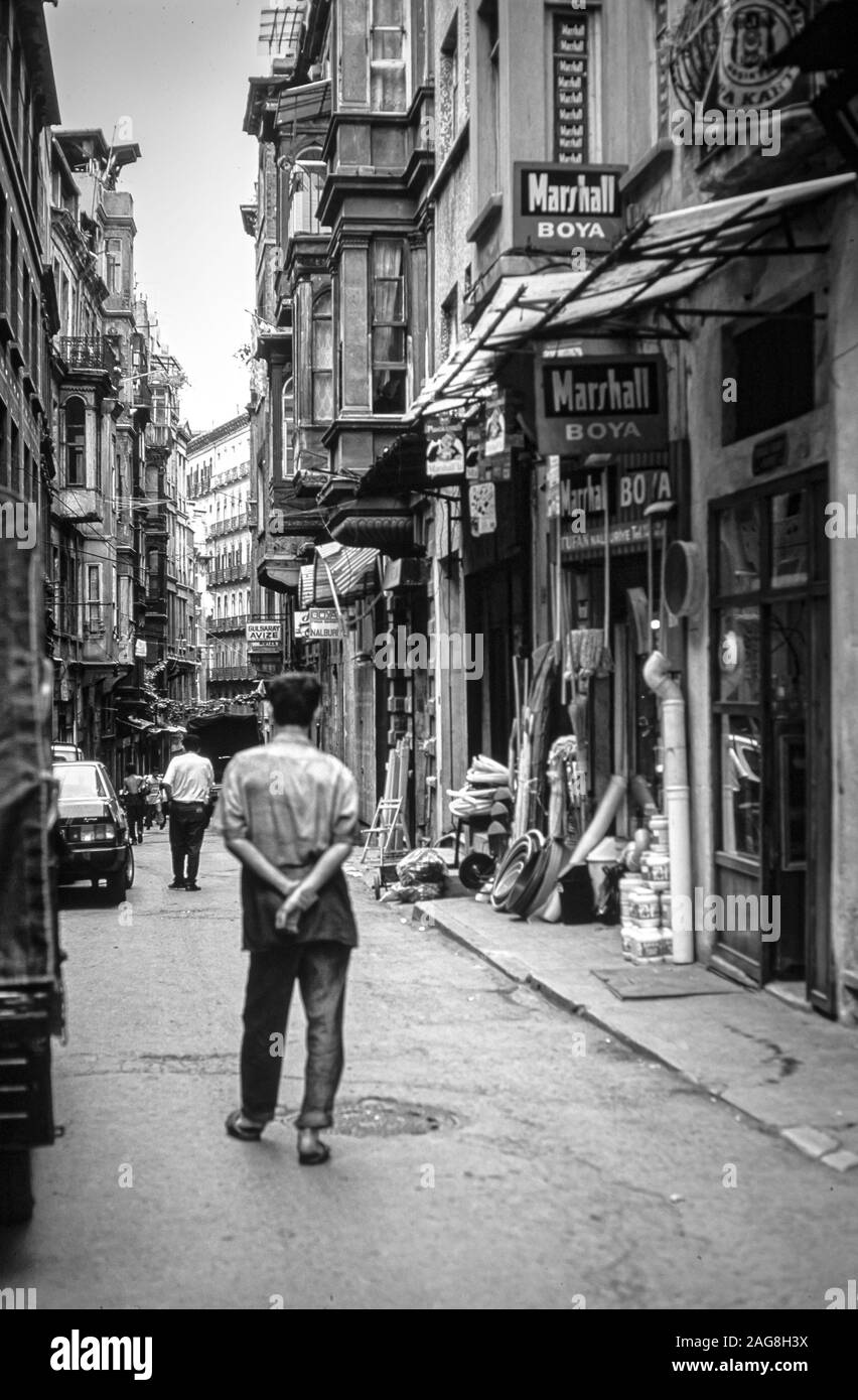ISTANBUL, TURKEY - Aug 08, 1993: A vertical grayscale shot of people walking in the narrow streets of Istanbul Stock Photo