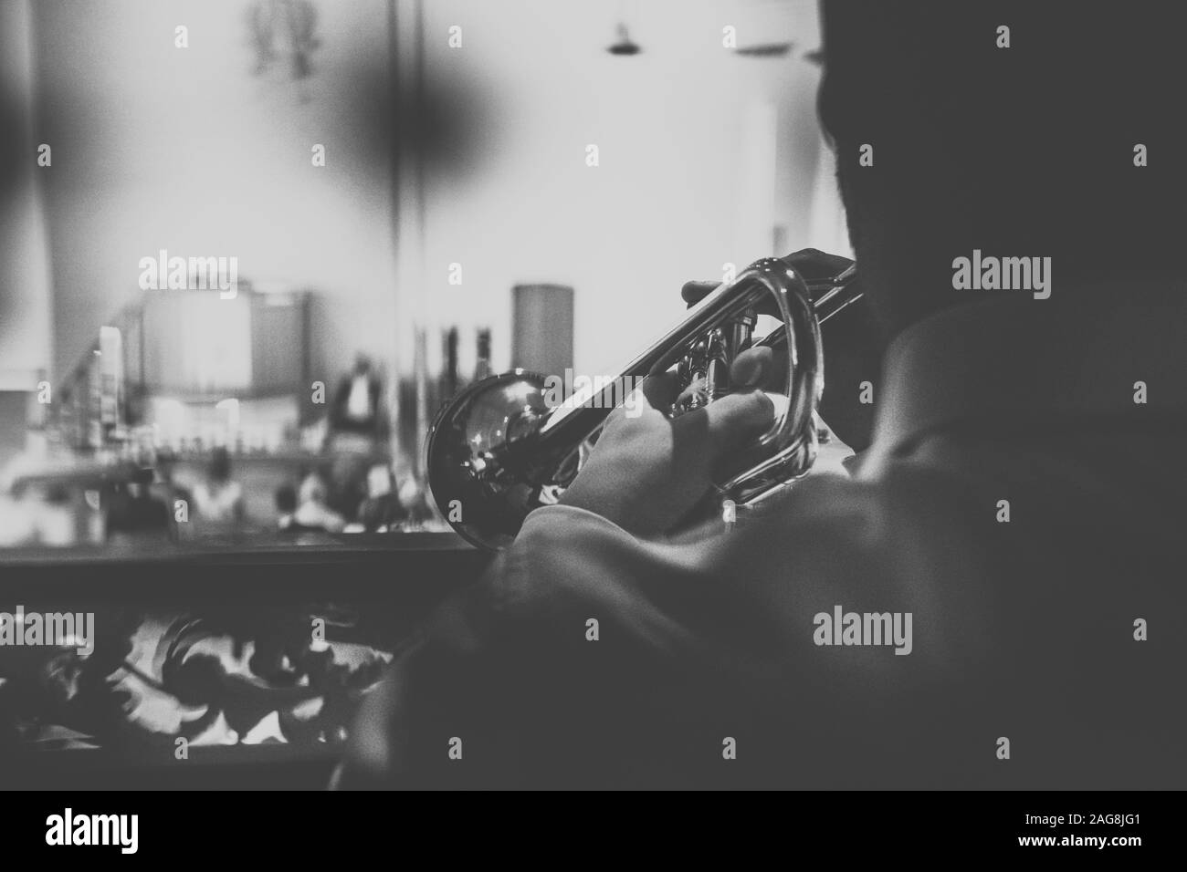 Grayscale shot of a person playing the trumpet in the church Stock