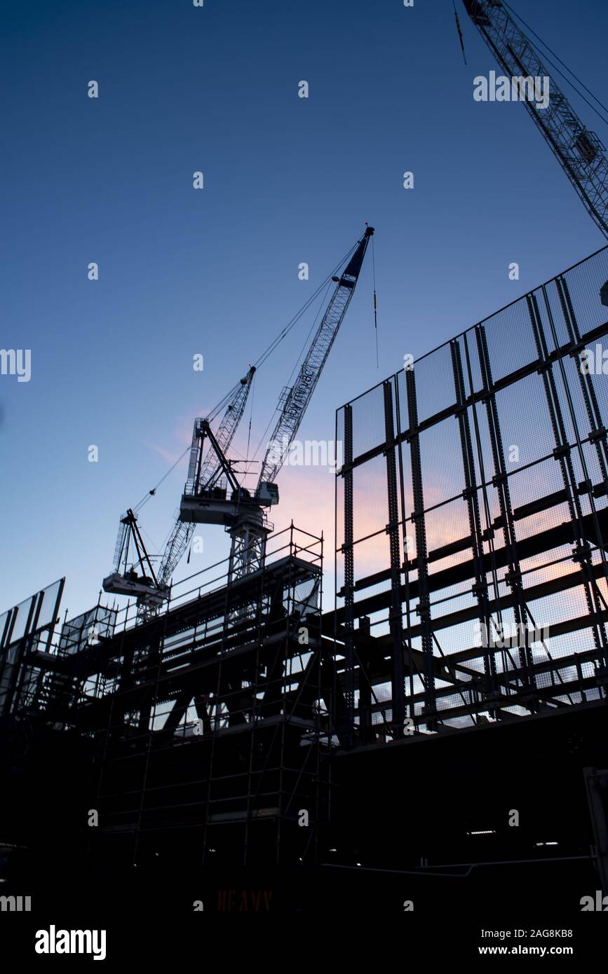 Vertical low angle shot of cranes in the process of construction of a ...