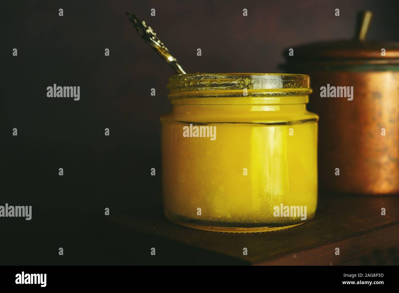 Homemade Ghee / Clarified butter in a glass jar on dark moody