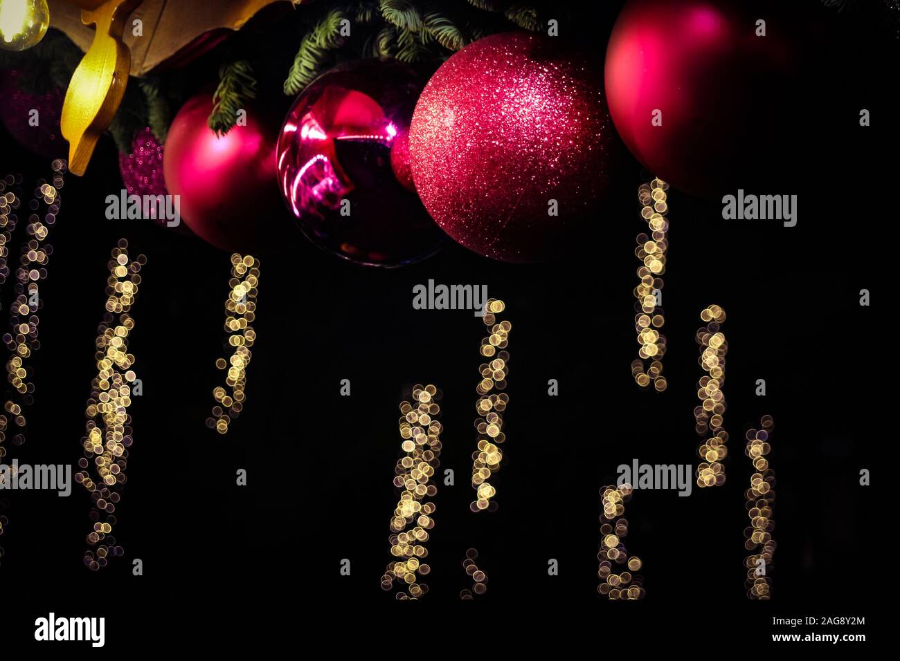 Red christmas ornaments and bokeh festive lights in the background, seen at Weimar christmas market, Germany. Stock Photo