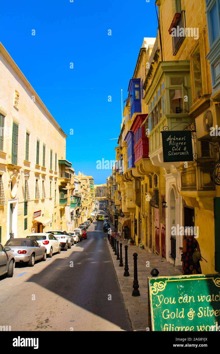Valletta, Malta - September 13, 2016: Street scene with tourists strolling through the narrow medieval streets of Valletta, Malta. Stock Photo