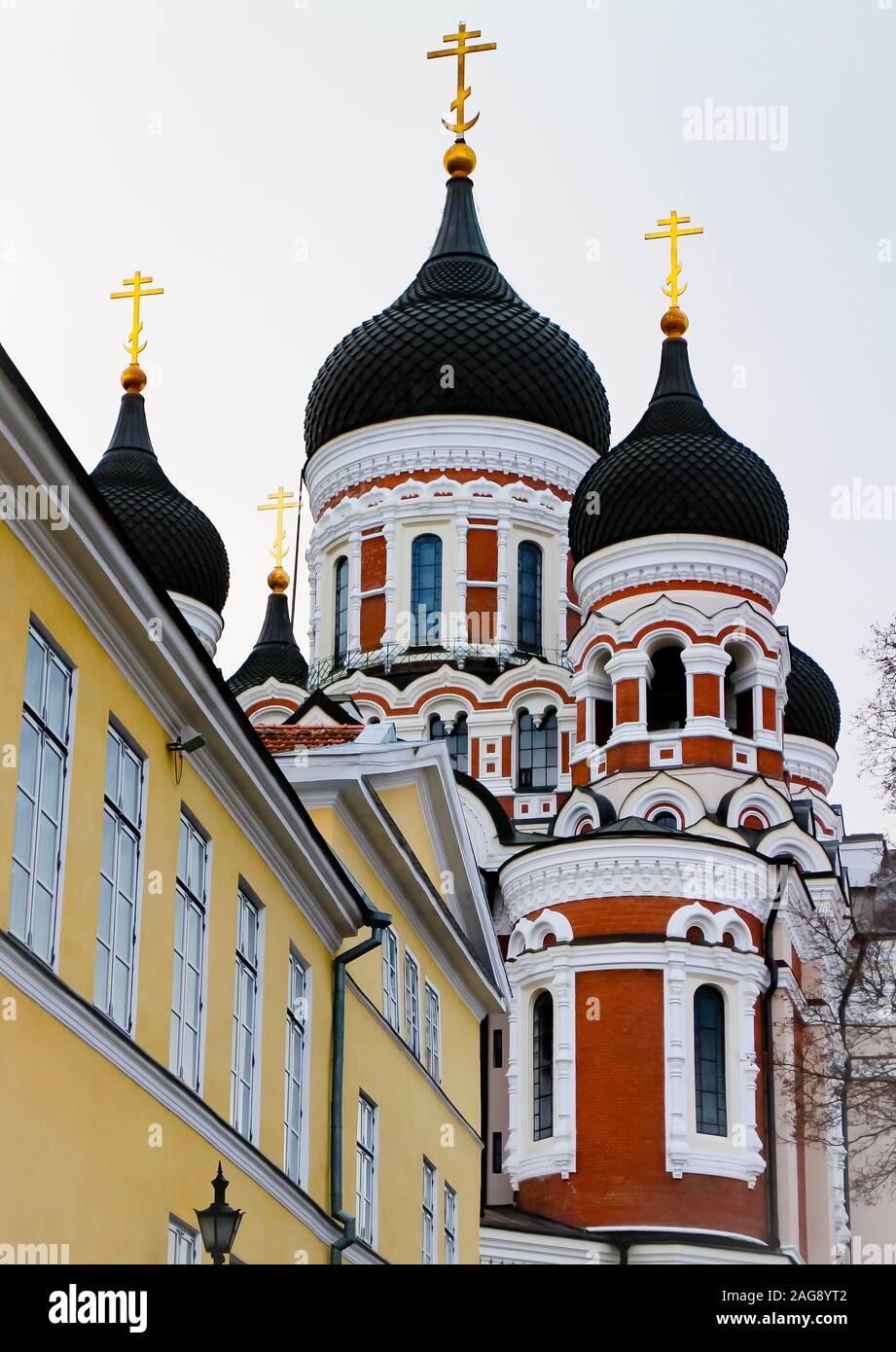 Alexander Nevsky Cathedral behind yellow old buildings on Toompea hill on a winter day in Tallinn Old Town, Estonia. Stock Photo