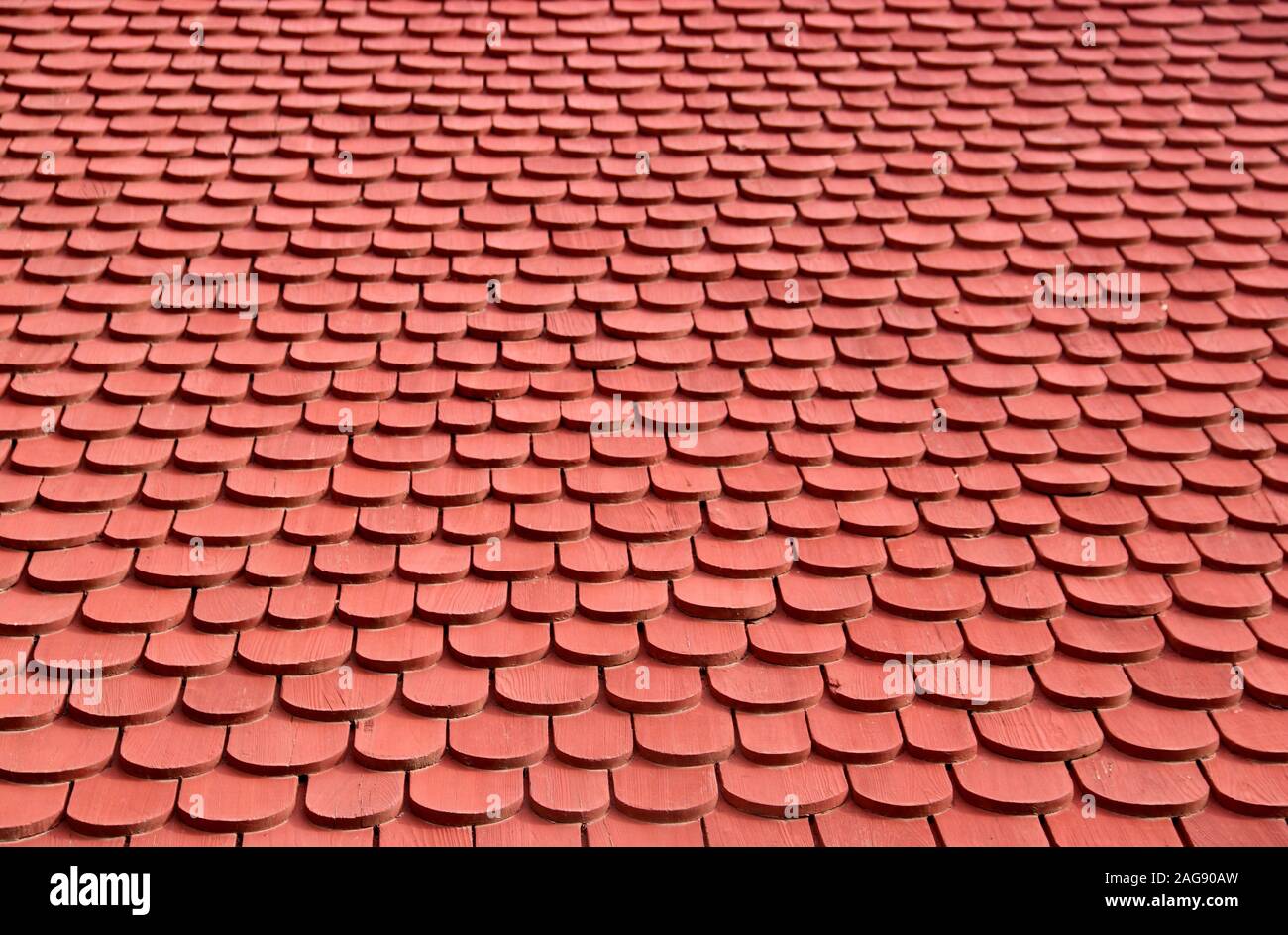 Red wooden shingles make a roof background Stock Photo