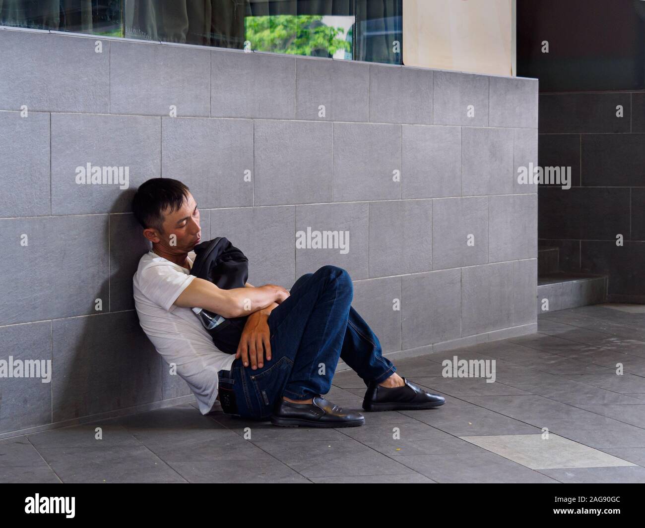 SINGAPORE 5 APR 2019 Tired exhausted Asian Chinese man napping