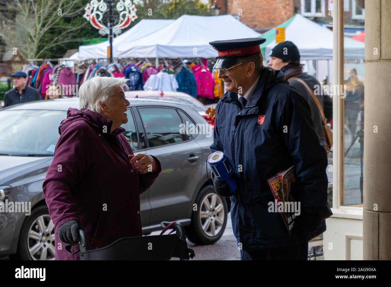 A member of the salvation army collecting money for charity at Christmas speaking to an elderly lady in the street Stock Photo