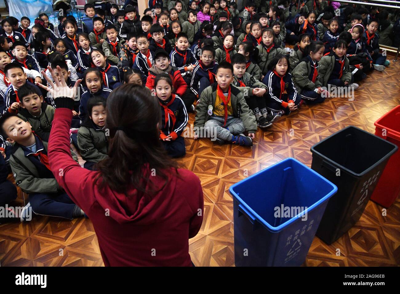 (191218) -- QINGDAO, Dec. 18, 2019 (Xinhua) -- A volunteer teaches pupils about garbage classification at the Juyuan Primary School in Qingdao City, east China's Shandong Province, Dec. 18, 2019. Youth volunteers for social service from the Qingdao Zhanqiao Bookstore launched a scientific information outreach program at the Juyuan Primary School Wednesday. Through video clips, knowledge contests, short dramas and amusing games, the volunteers attempted to help the pupils better understand the necessity of garbage classification as well as the importance of environmental and ecological protecti Stock Photo