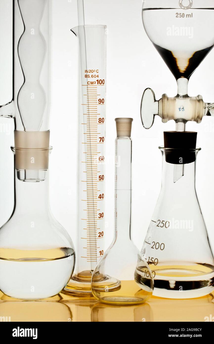 Chemical flasks, a volumetric flask and a measuring cylinder in a chemical laboratory Stock
