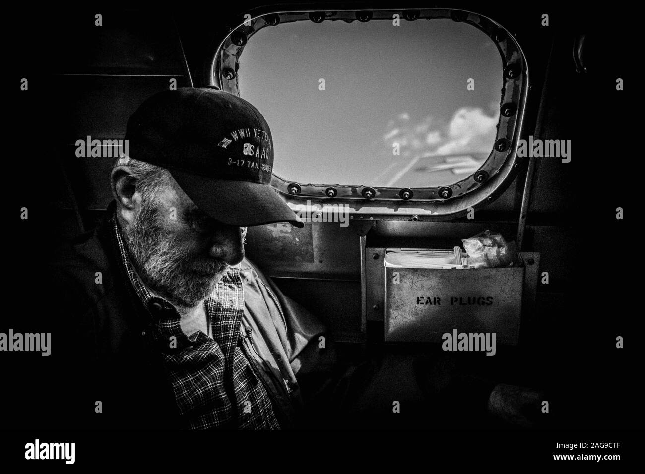 Gray scale shot of a WWII Veteran riding in a B-17 bomber plane Stock Photo