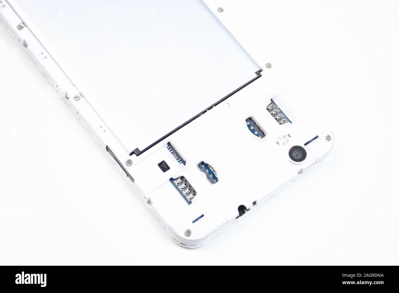 A cell phone with an open cover lies face down on a white background