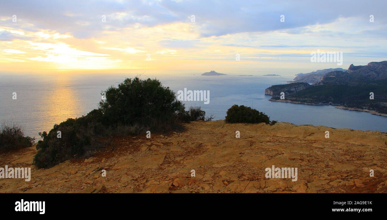 A bay surrounded by rock formations with the beautiful view of the sunrise in the background Stock Photo