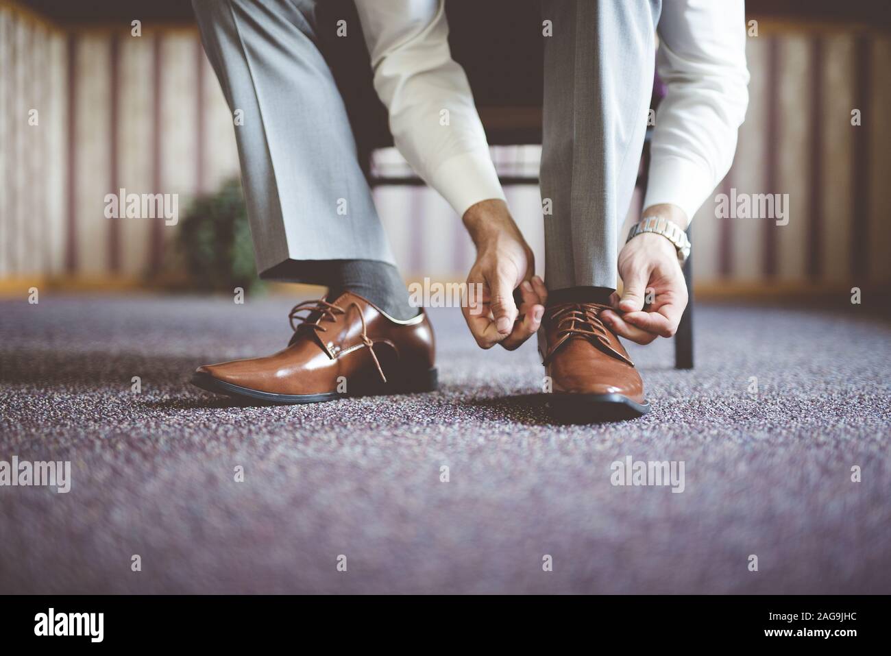 Closeup shot of a well-dressed suit tying his shoes and getting ready for a business meeting Stock Photo