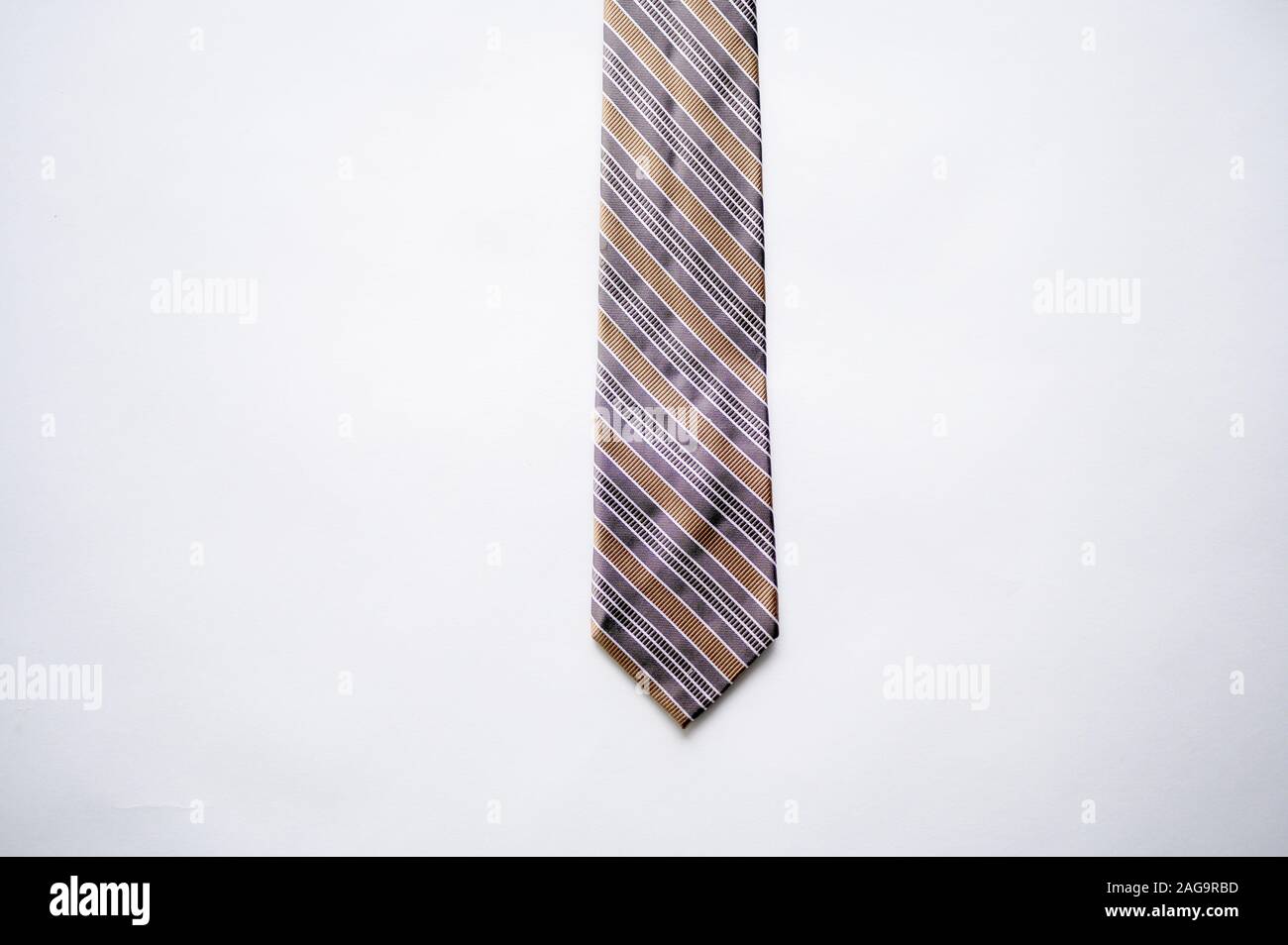 Overhead shot of a striped tie on a white surface Stock Photo