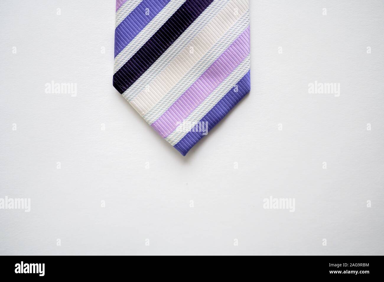 Overhead shot of a striped tie on a white surface Stock Photo