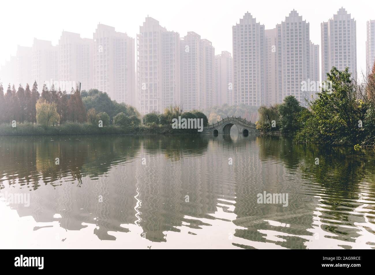 The traditional Chinese architecture semicircle bridge over Fuhe and Jiangan rivers in Nanhu Wetland park of Chengdu, Sichuan, China. Air pollution Stock Photo