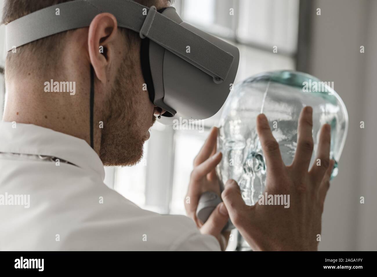 Person wearing virtual reality goggles holding a transparent mannequin ...
