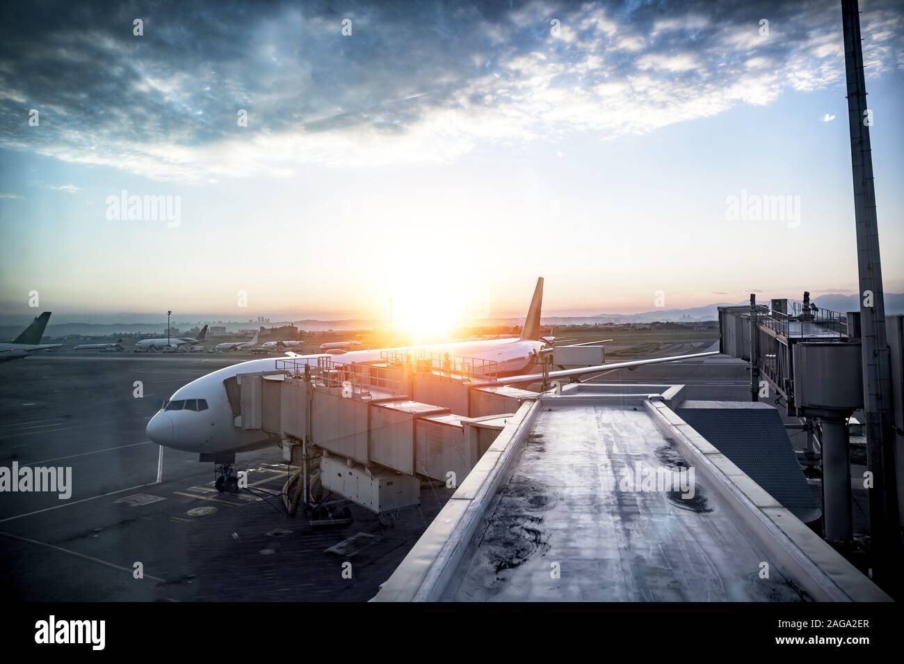 Beautiful shot of an airplane at the station with the sun shining in the background Stock Photo
