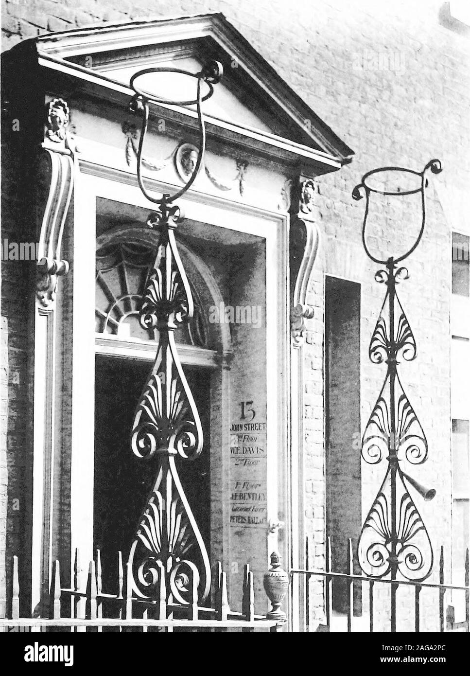 . English ironwork of the XVIIth & XVIIIth centuries; an historical & analytical account of the development of exterior smithcraft. FIG. 124. EXTINGUISHER FORMERLY IN SPRING GARDENS. Fhite rXXXl.. flniffliniEf [ PAIR OF LAMP HOLDIiKS IN JOHN STREET, ADELPHI.by Adiims Bmilters. Lamp-Holders 281 a pattern of vesica over honeysuckle and fan. No less richbut of slender classic lyre outline, with honeysuckle, scrolls,and rosettes, (Plate lxxiii) are those to Chandos House atthe east end of Queen Street, Cavendish Square (page 244).Those to Sir Watkyn Wynnes house, also designed by RobertAdam (page Stock Photo