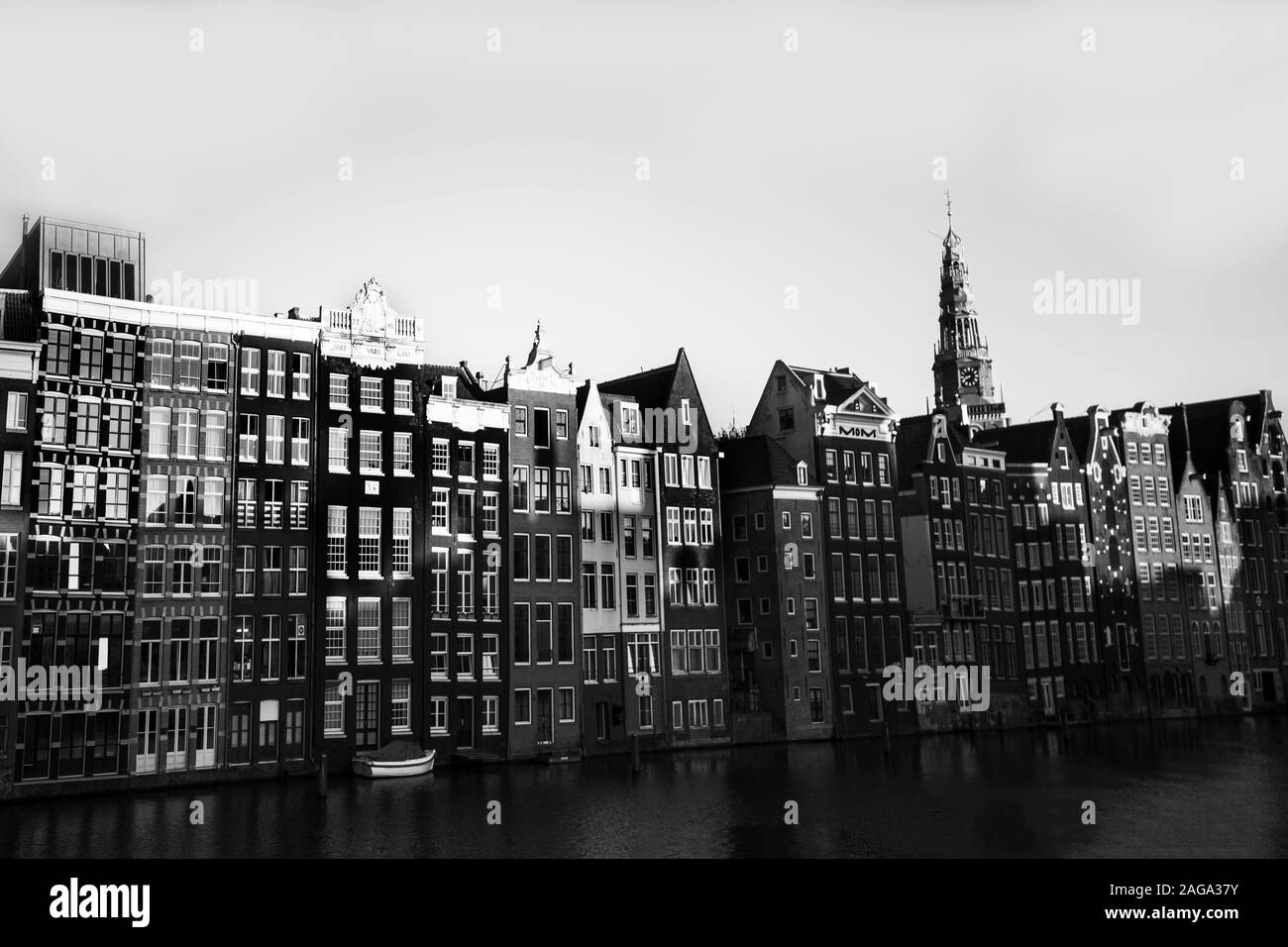 Grayscale shot of apartment buildings near the river under the clear sky Stock Photo