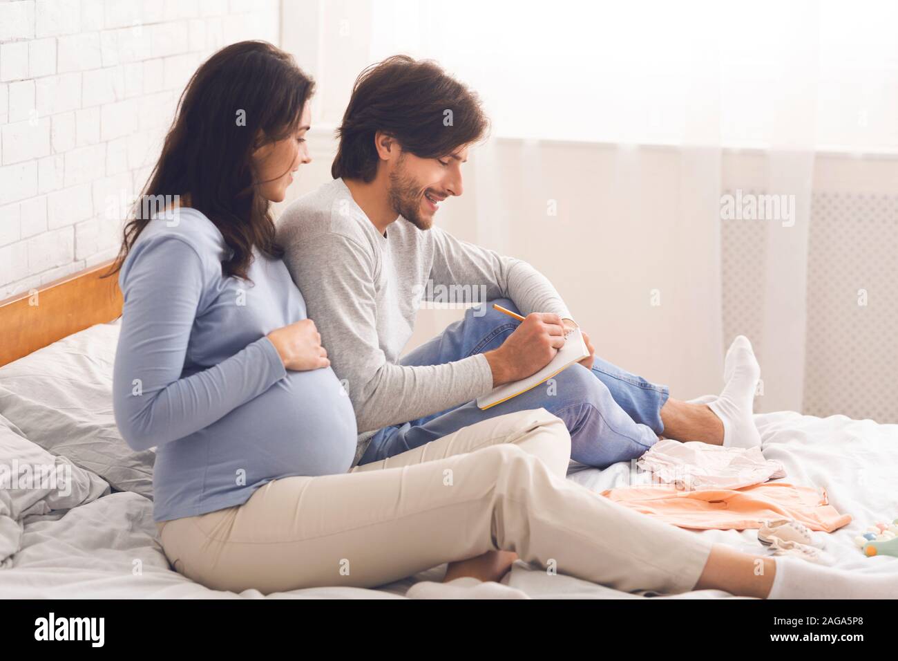 Expecting couple writing checklist before going to maternity hospital Stock Photo