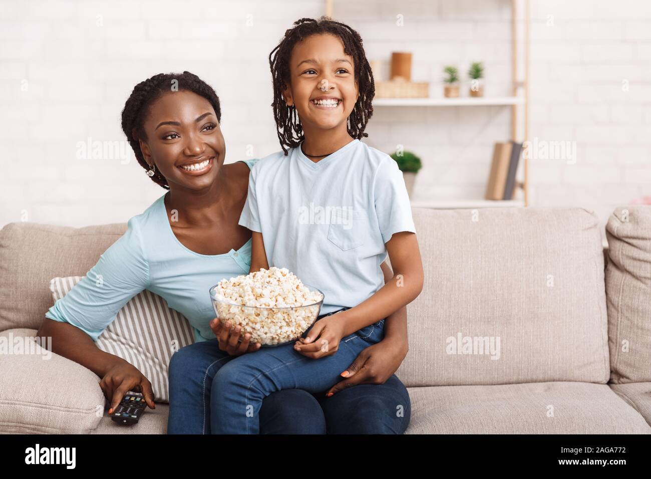 Afro family eating popcorn and watching tv together Stock Photo