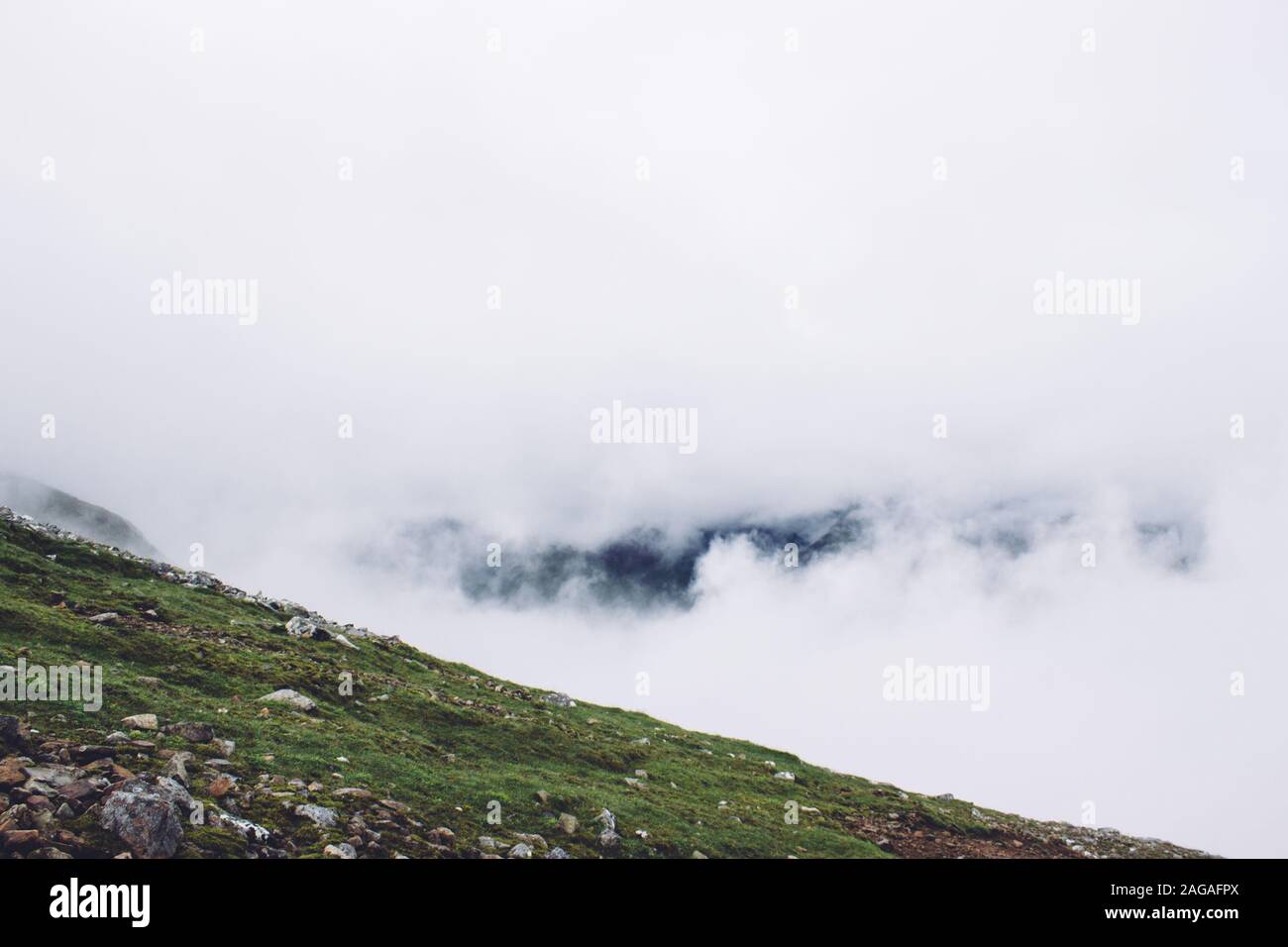 Scenery of smoke coming out of the mountains in the middle of a green view Stock Photo