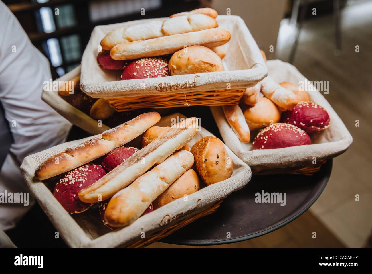 Delicious air bread with a crisp crust lies in a wicker basket, ready to serve. Stock Photo