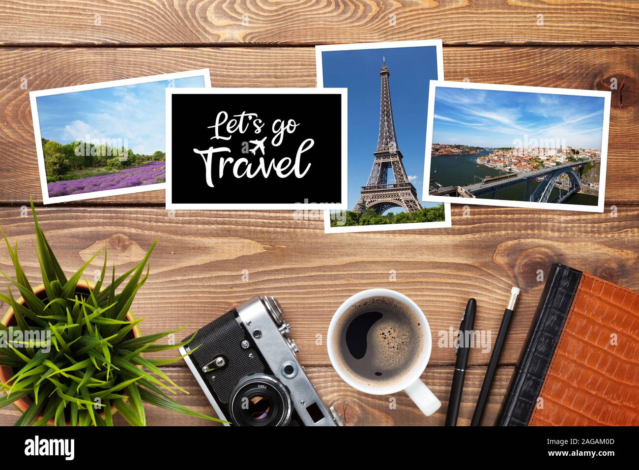 Camera, travel photos and supplies on office wooden desk table. Top view with copy space Stock Photo